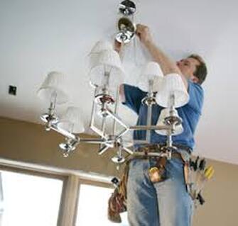 Man installing chandelier
